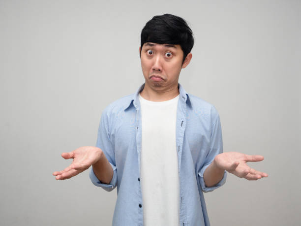 istock Confused asian man blue shirt posing hands up I don't know isolated 1431043421