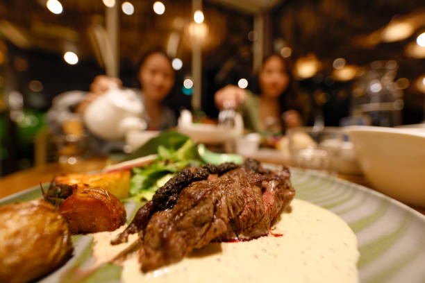 Grilled beef tenderloin steak on a white platter is served with demiglas sauce