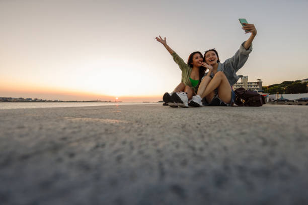 istock Two women taking selfie in tourist with sunset background 1431044055