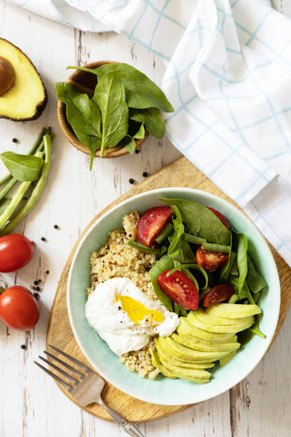 istock Keto diet. Delicious breakfast or brunch - poached egg, quinoa, avocado and fresh vegetable salad on the kitchen table. View from above. 1431049514