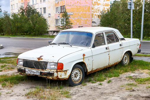 Novyy Urengoy, Russia - August 26, 2022: Rusty abandoned motor car GAZ-31029 Volga in the city street.