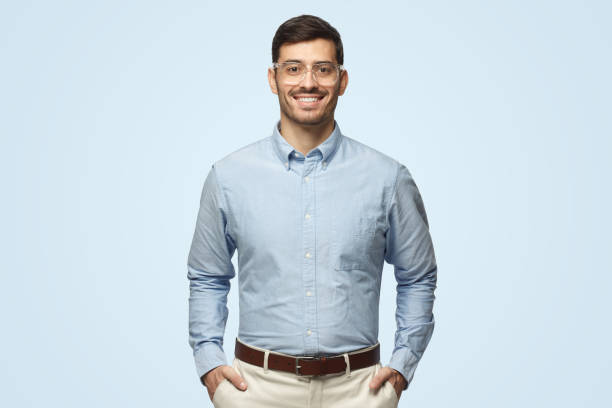 istock Smart businessman smiling at camera, wearing transparent glasses, isolated on blue background 1431058024
