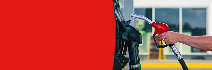 Man holds a refueling gun in his hand for refueling cars. Gas station with diesel and gasoline fuel close-up