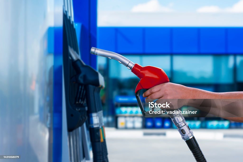 Man holds a refueling gun in his hand for refueling cars. Gas station with diesel and gasoline fuel close-up. Man holds a refueling gun in his hand for refueling cars. Gas station with diesel and gasoline fuel close-up Oil Pump Stock Photo