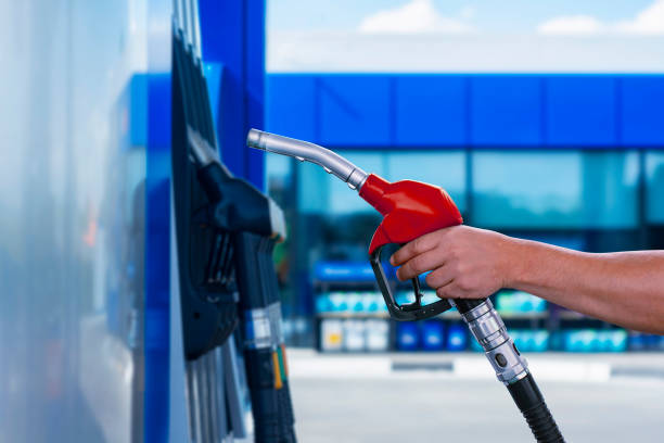 Man holds a refueling gun in his hand for refueling cars. Gas station with diesel and gasoline fuel close-up. Man holds a refueling gun in his hand for refueling cars. Gas station with diesel and gasoline fuel close-up benzine stock pictures, royalty-free photos & images