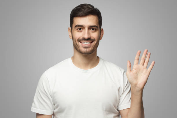 istock European man greeting someone with open hand, smiling, enjoying communication 1431059278