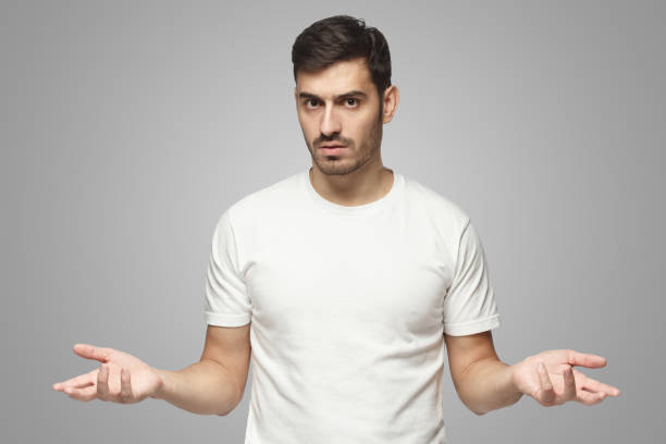 istock Young man spreading hands not knowing what to do, isolated on gray 1431059303
