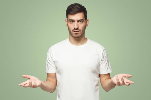 istock European man spreading hands not knowing what to do, isolated on green background 1431059314