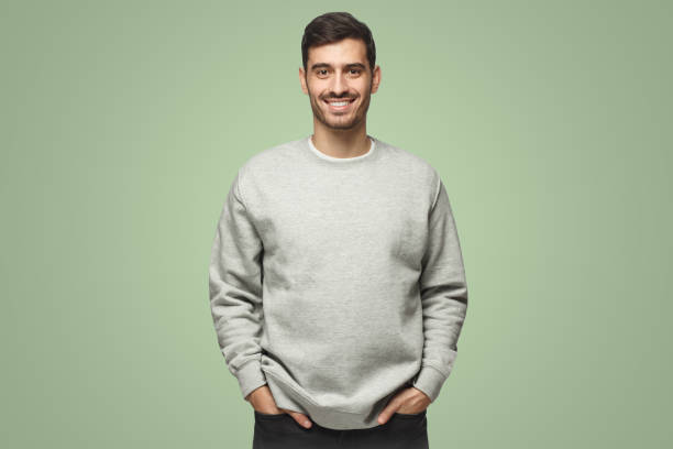 istock Young handsome man in gray sweatshirt isolated on green background 1431059513