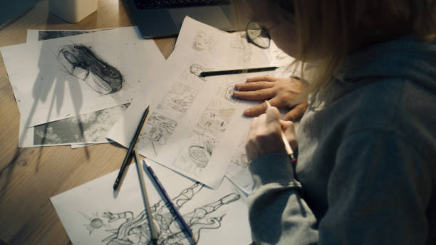 Female creative designer works on storyboard and draws sketches for her project stock photo