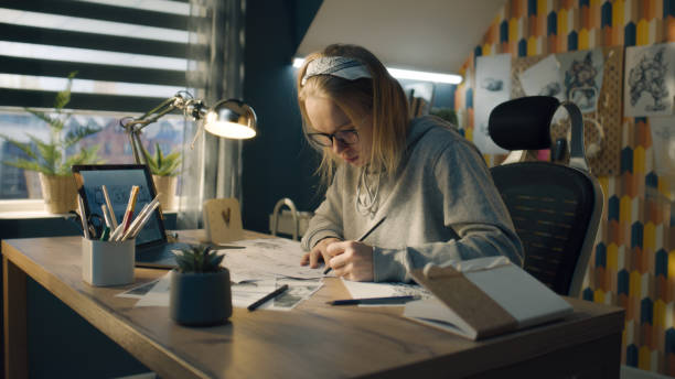 istock Blonde woman works on a storyboard in a home based design studio makes sketches 1431067529