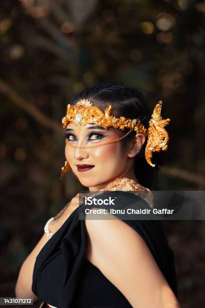 The Face Of A Balinese Woman Wearing A Gold Crown And Makeup On Her Face With Beautiful Skin Chilling Stock Photo - Download Image Now