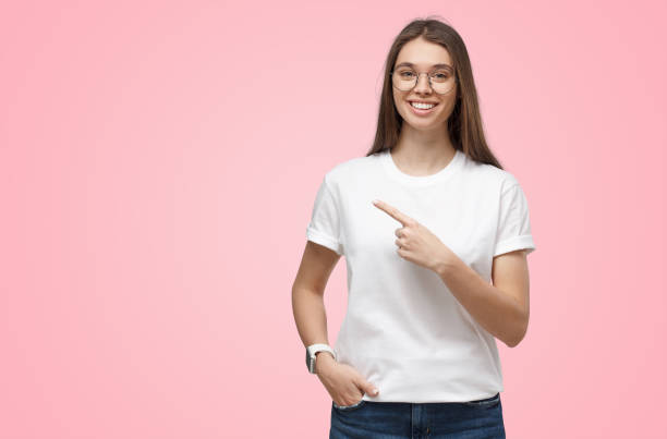 istock Young pretty girl pointing left, looking excited on pink background with copy space 1431071385