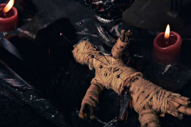 istock Voodoo Magic concept. Voodoo doll studded with needles with pierced rag heart on pentagram and around burning candles. Spooky or eerie magical esoteric ritual. 1431072286
