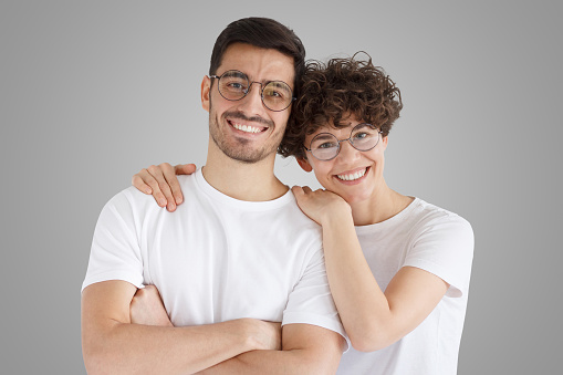 Cheerful young couple standing isolated on gray background