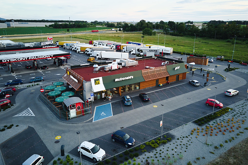 McDonalds restaurant near highway, aerial view. McDonald's cafewith parked cars. Katy Wroclawskie, Poland - June 17, 2022