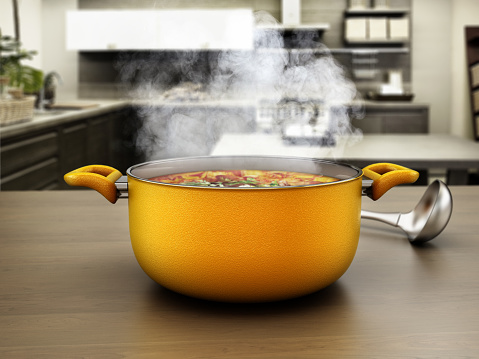 Boiling meal inside yellow cooking pot on modern kitchen counter.