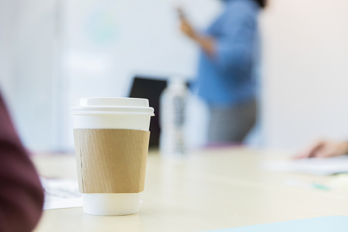 Color image of a coffee cup sitting on the conference room table.