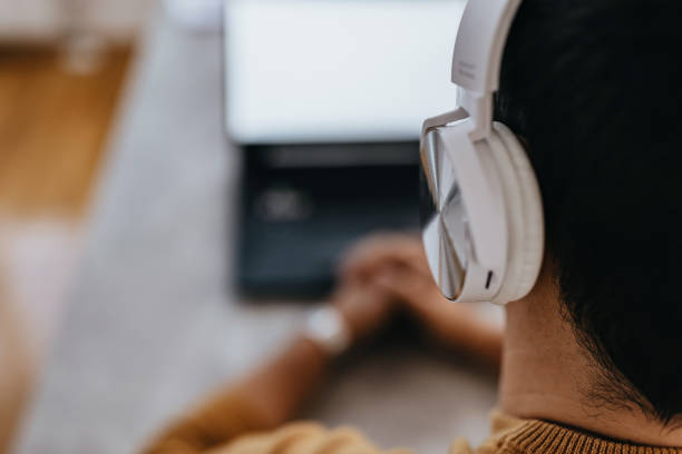 istock Man with headphones in front of laptop 1431085367