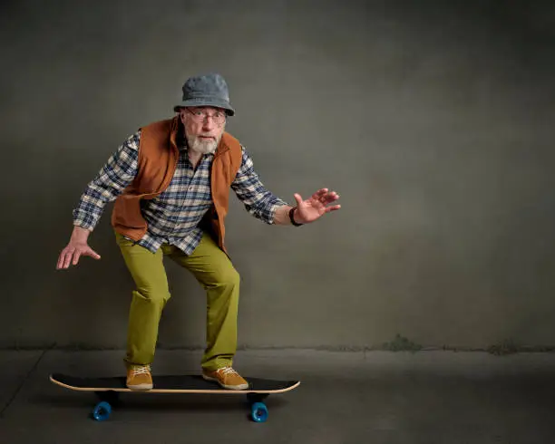Photo of senior man riding a long cruising skateboard