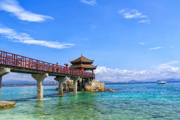 Red trestle bridge with blue sky and blue sea and seaside