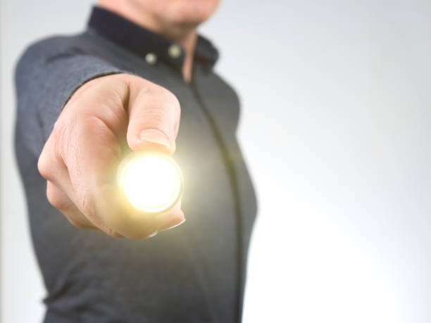 istock man holds a flashlight in his hand. item for camping and household life 1431093747