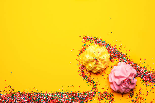 White shell plate full of chocolate candies with blue icing, cookies with shells, stars on the table with shining cloth. Summer season delicious on the party. Sea time theme on the candy bar.