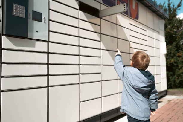 pacco di ritiro. bambino che mostra la scatola della porta aperta al terminale automatico di consegna postale. terminal postale self-service e concetto di consegna pacchi - mailbox mail box open foto e immagini stock