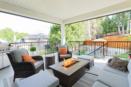 A spacious deck with a fire pit table heater