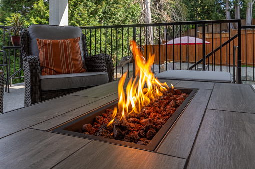 A spacious deck with a close up shot of a fire pit table heater
