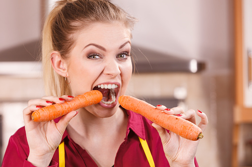 Young woman eating carrots