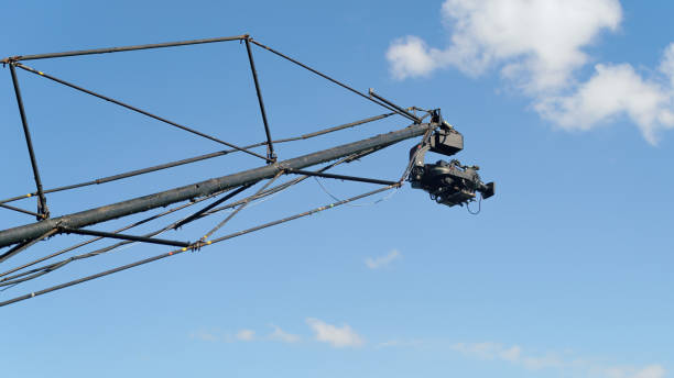 TV camera on a big high crane against the blue sky. Abstract TV or filming theme image with copy space
