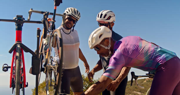A group of middle-aged African-American men wearing lycra cycling clothes preparing for a morning ride on a sunny day in the Santa Monica Mountains in Malibu, California.
