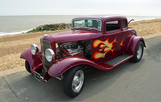 Felixstowe, Suffolk, England -  August 27, 2016: Classic Hot Rod  parked on seafront promenade  beach and sea in background.