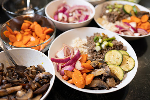 Bibimbap - Korean Rice Bowl - Served as a bowl of warm white rice and beef topped with red onions, carrots, mushrooms, zucchini, and scallions. 
Shot with R5 in Kitchen