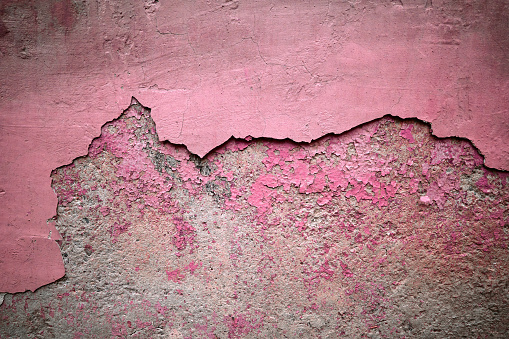 Texture background gray wall with pink peeling paint plaster, half full frame