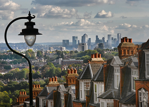 Beautiful period red brick home rooftops in a London suburban hill terrace overlooking the distant view of downtown  financial district offices. London, UK