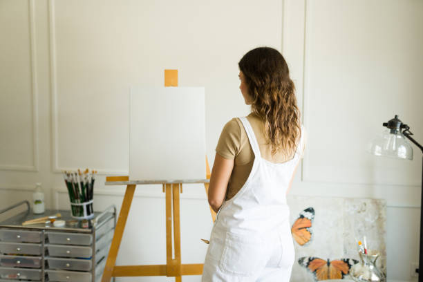 istock Female painter seen from behind looking at a blank canvas and getting inspired 1431126897