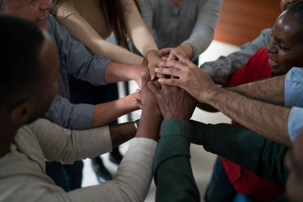 istock Multi racial group of students and teachers at technology course for adults holding hands in celebration 1431126981