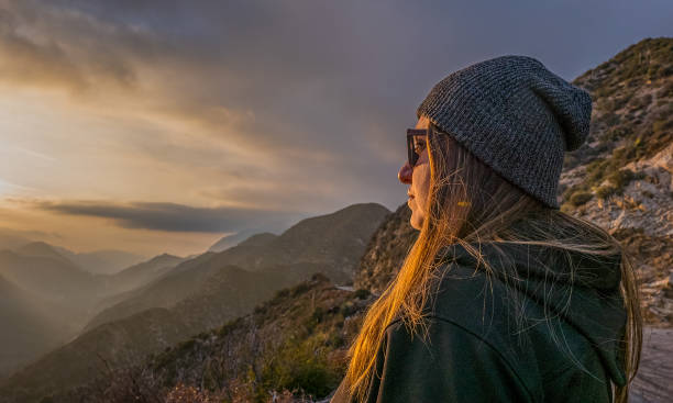 istock Woman looks into the setting sun 1431132310