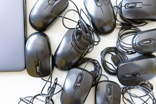 Detailed background of a laptop keyboard, mouse and small wired headphones