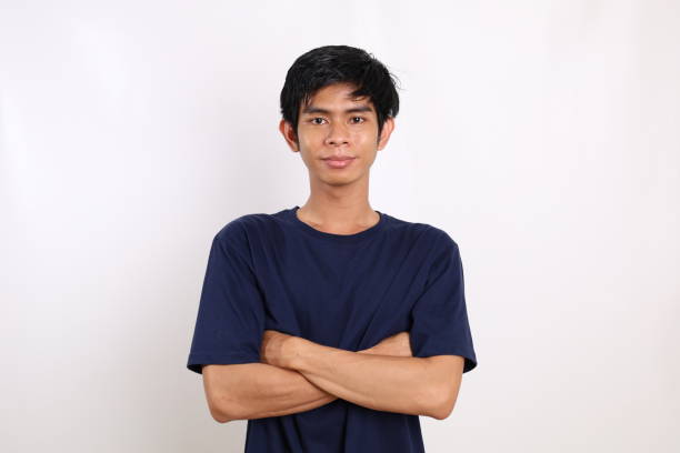 istock Asian young man standing with folded hands while looking at the camera. Isolated on white background 1431150231