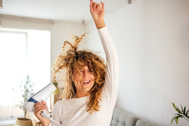 istock Woman is having fun while drying her hair 1431150384