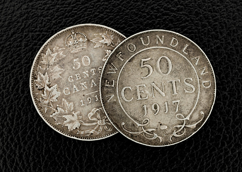 Silver coins of American currency isolated with black background.