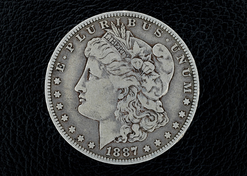 Silver coins of American currency isolated with black background.