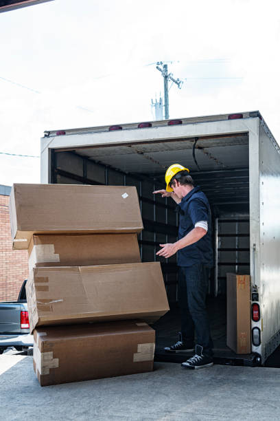 istock Delivery Worker Watching Cardboard Cartons Fall Off Hand Truck 1431175276