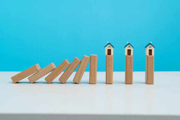istock Wooden dominos falling to a model house 1431187857