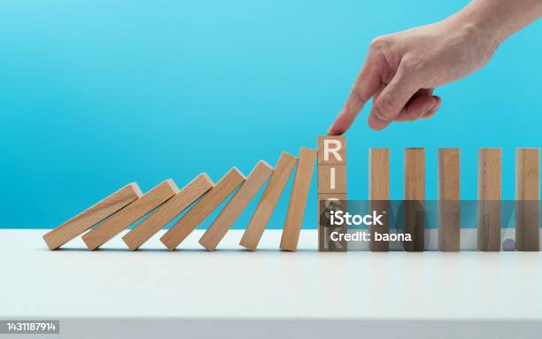 Man Hand Stopping The Dominos Falling Stock Photo - Download Image Now - Risk, Prevention, Falling
