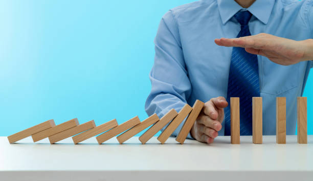 istock Businessman hand stopping the dominos falling 1431188077