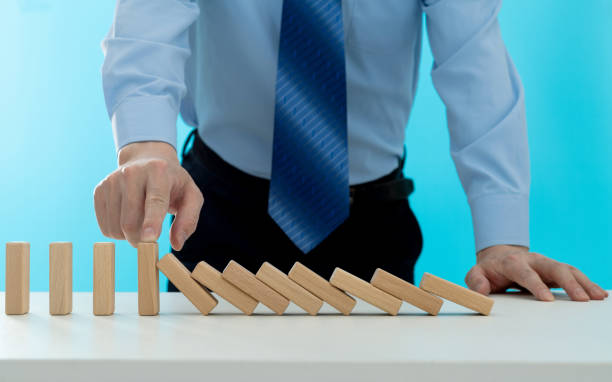 istock Businessman hand stopping the dominos falling 1431188091